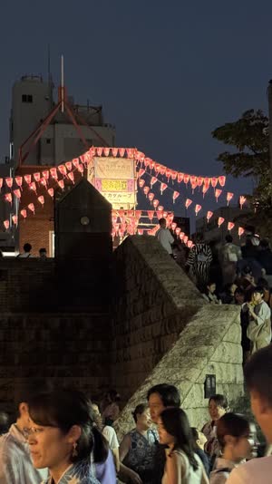 Traditional Obon lantern glowing softly at the eaves of a Japanese house at night, warm gentle light, delicate paper texture, quiet welcoming mood