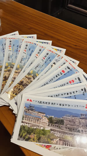 Close-up of official Japan travel guide pamphlets fanned on a wooden desk, crisp paper texture, warm library light