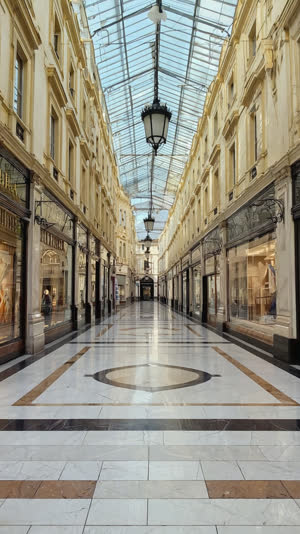 Low-angle shot of a spotless shopping arcade floor stretching into the distance, polished tiles reflecting morning light