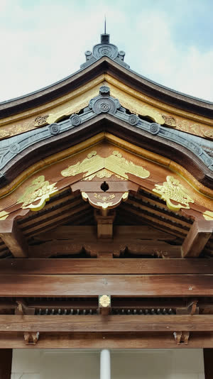 Detail of a Japanese shrine structure showing stacked wooden bracket arms under the eaves, cypress timber, dignified atmosphere, photorealistic documentary photograph, natural…