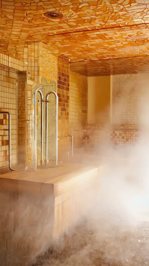 Retro 1960s Japanese bath facility interior, patterned tile walls, rising steam, vintage fixtures and frosted glass, nostalgic warm tones