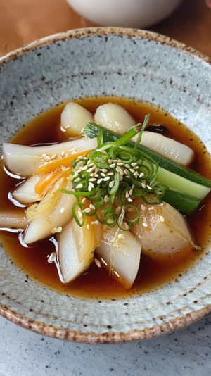 Overhead macro of a small bowl of Japanese marinated vegetables, glossy dressing, careful garnish, refined texture on rustic ceramic, soft light