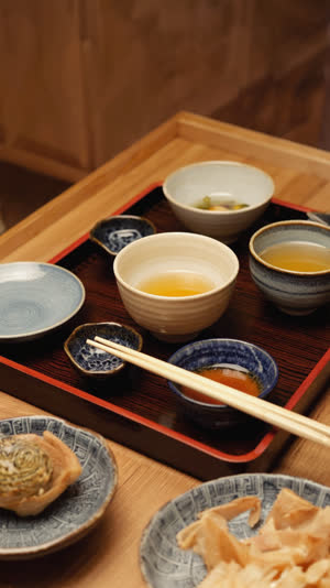 Finished Japanese meal tray with cleanly emptied bowls viewed from above at an angle, satisfied stillness, warm home lighting