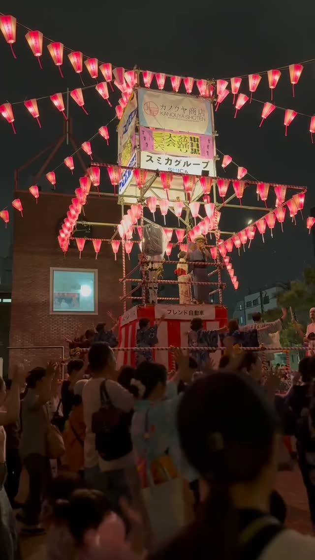 Inside a turning circle of Bon Odori dancers, yukata sleeves swinging in unison, hands raised mid-gesture, lantern light streaking with motion blur, joyful summer night energy,…