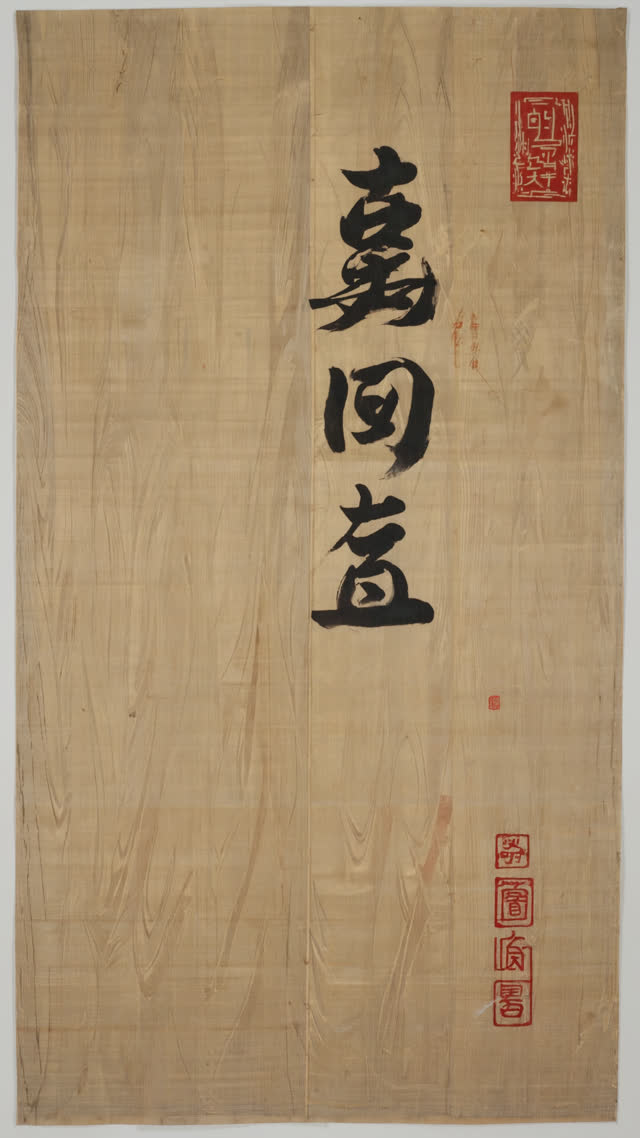 Overhead arrangement of clear sake in a carafe, dark miso paste in a bowl, soy sauce in a small dish and rice vinegar, contrasting colors on dark wood