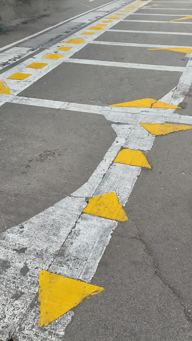 Boarding position markers and painted queue lines on a platform floor, weathered paint texture, clean geometry, morning light